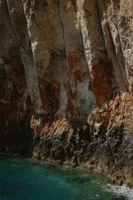 Majestic rocky cliffs rising above the clear sea in Zakynthos, Greece.