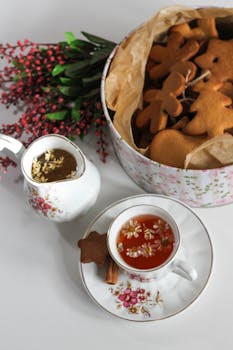Fresh gingerbread cookies and herbal tea create a festive atmosphere with a floral background, perfect for holiday moments.