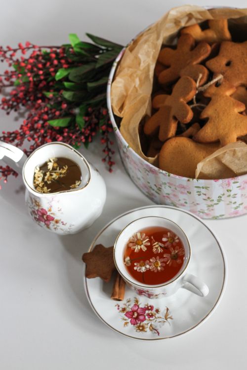 Free Fresh gingerbread cookies and herbal tea create a festive atmosphere with a floral background, perfect for holiday moments. Stock Photo
