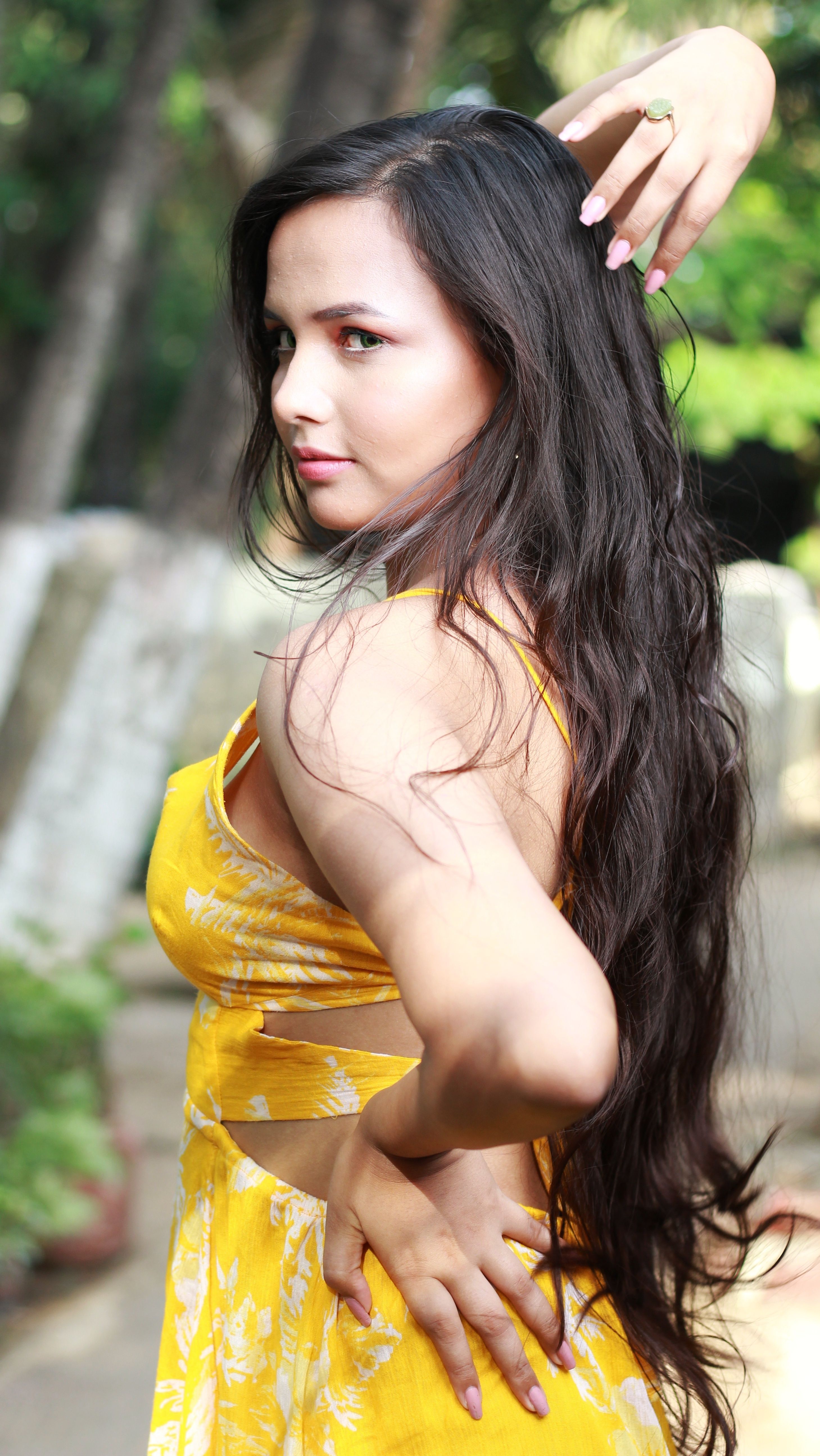 Beautiful young woman in a yellow dress posing outdoors in Mumbai, India.
