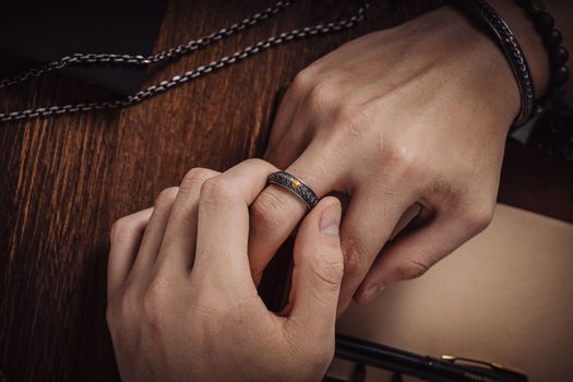 Detailed image of hands wearing a silver ring, capturing elegance and texture.