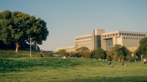 Free A scenic urban park with people relaxing against a backdrop of modern buildings. Stock Photo