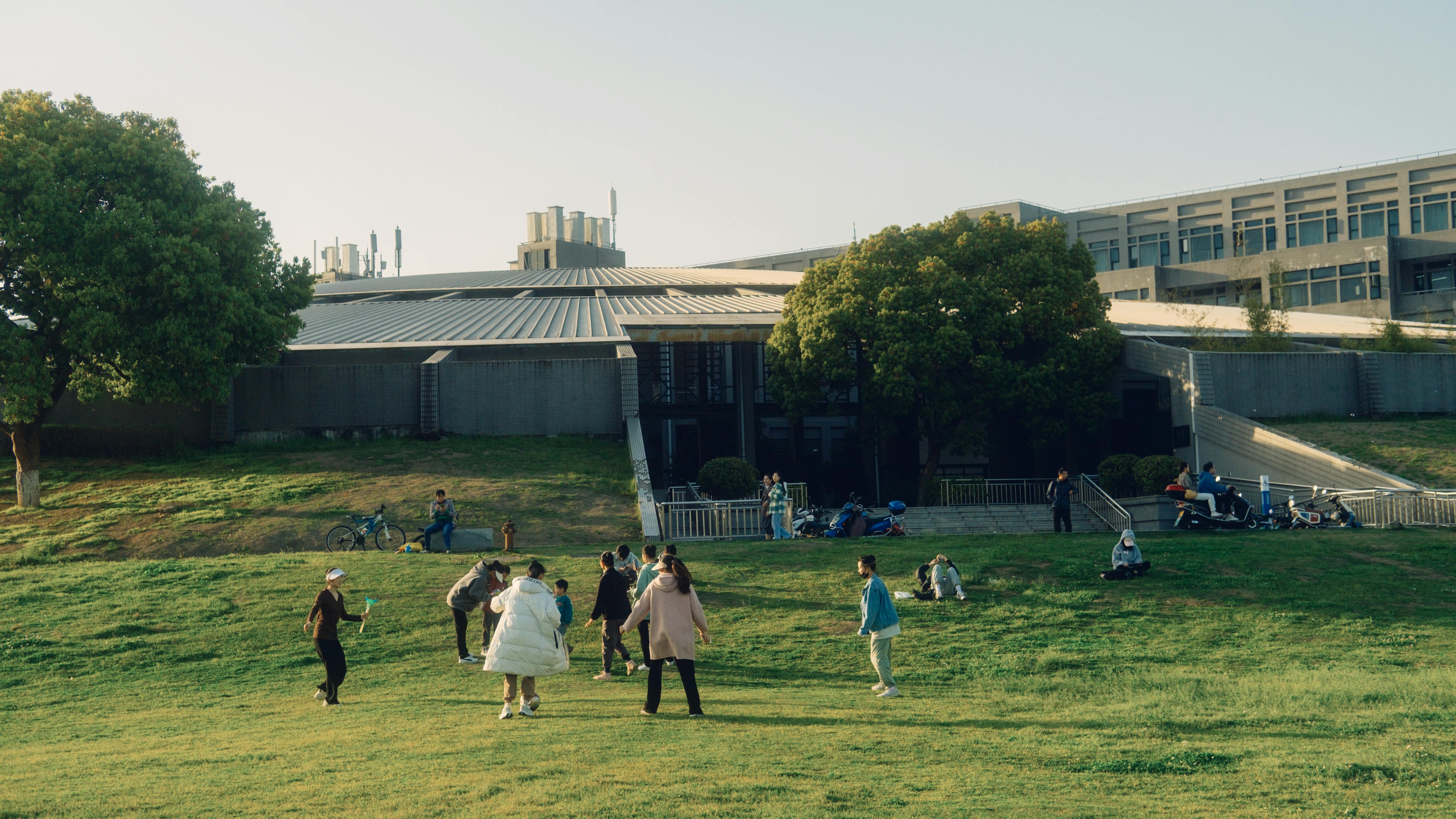 Families walking into Christ Embassy Ho Loveworld Arena in Barracks Newtown, modern architecture, sunny day