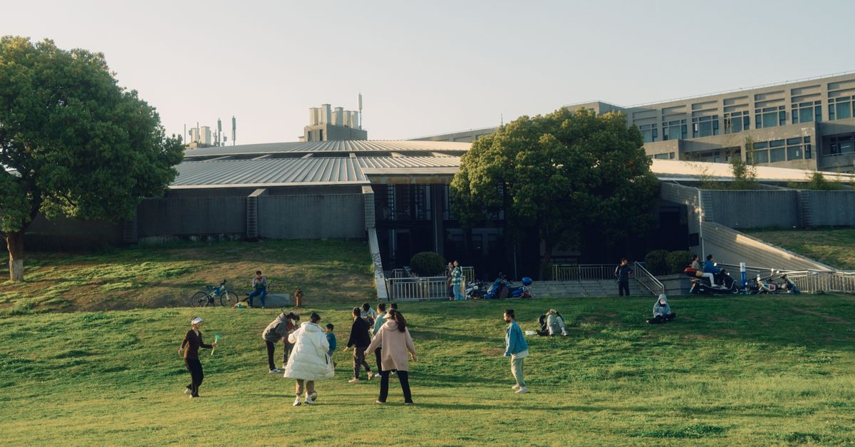 Families walking into Christ Embassy Ho Loveworld Arena in Barracks Newtown, modern architecture, sunny day