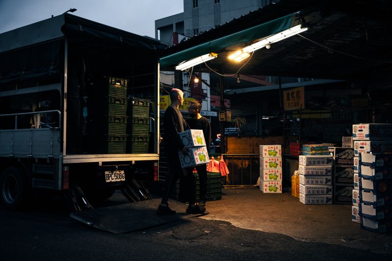 Workers unloading boxes from a delivery truck for same-day delivery