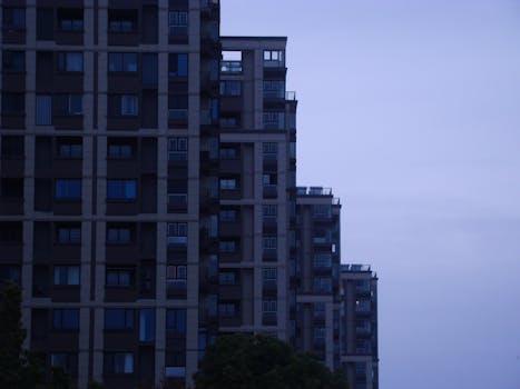 A contemporary skyscraper in a cityscape at dusk showcasing modern architectural design.
