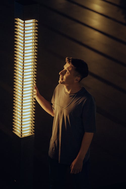 Man Standing near Lamp at Night