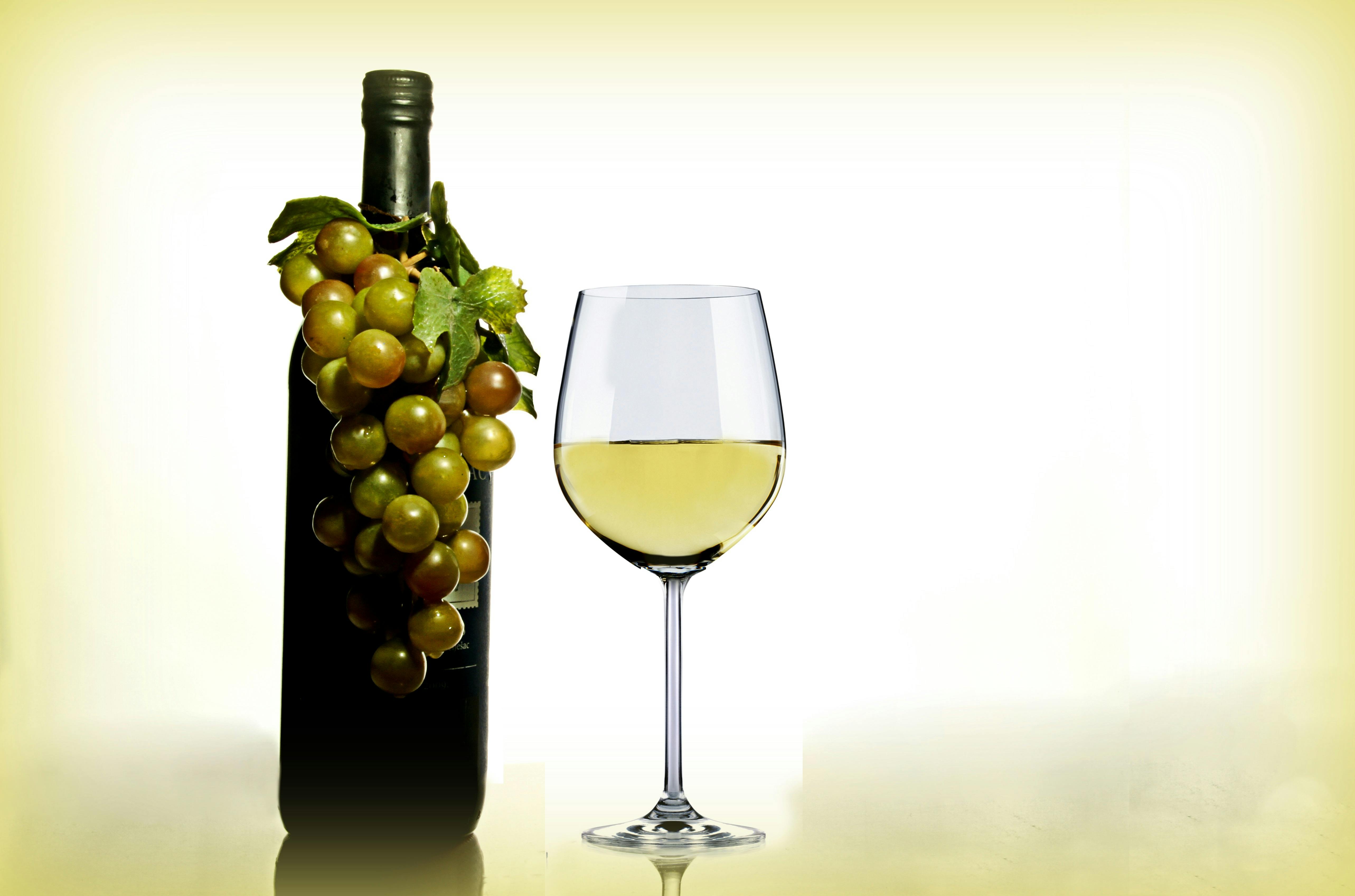 Wine in Wine Glass Near Green Glass Bottle