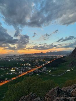 Captivating sunset over Qurago cityscape with dramatic clouds and distant hills in Sulaymaniyah, Iraq.
