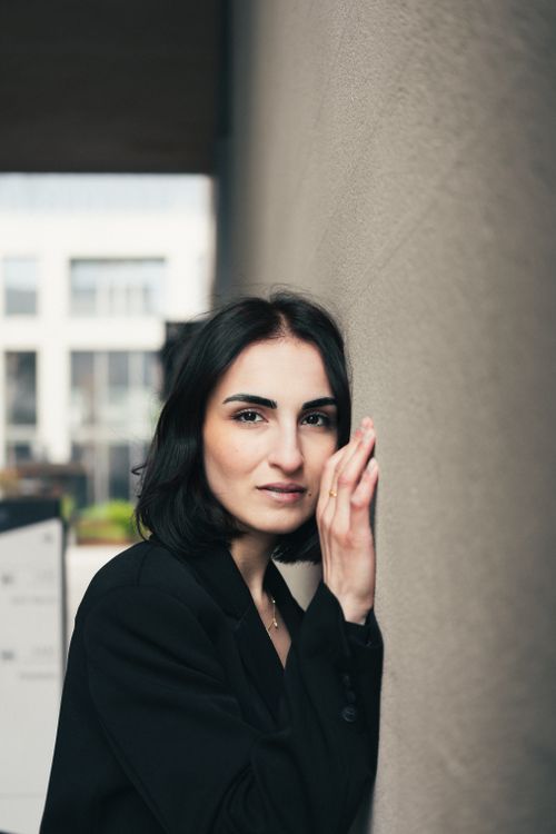Free Stylish woman in black jacket poses elegantly against a wall in Istanbul. Stock Photo