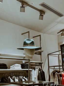 Stylish hat displayed on a mannequin in a chic fashion store interior.