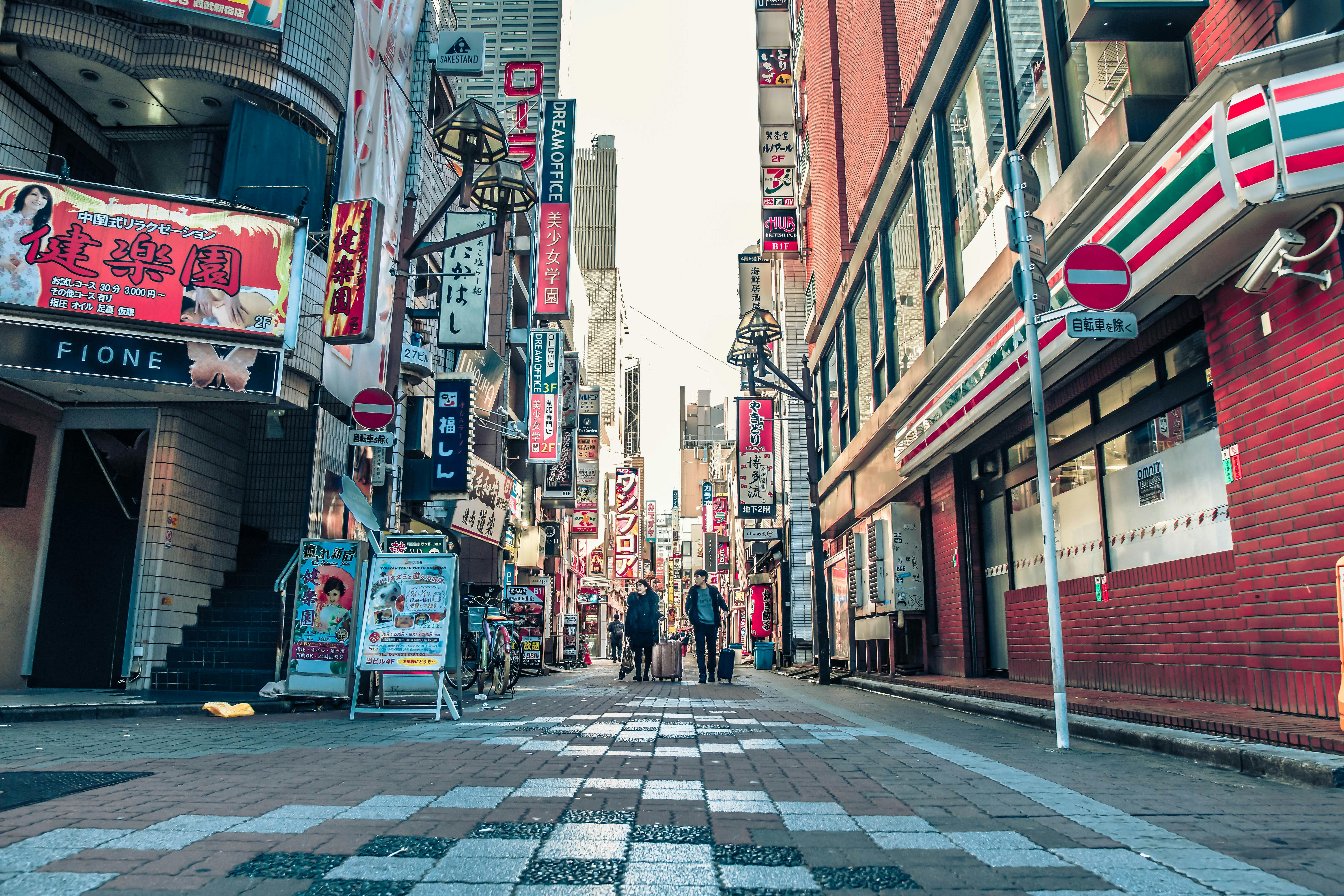 东京的街景热闹非凡，有标牌、建筑物和来往的行人