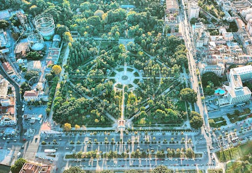 Stunning aerial shot of a lush urban park in downtown Palermo, Sicily, showcasing vibrant greenery and cityscapes.