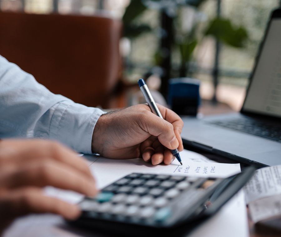 Persona haciendo cuentas con una calculadora y un bolígrafo