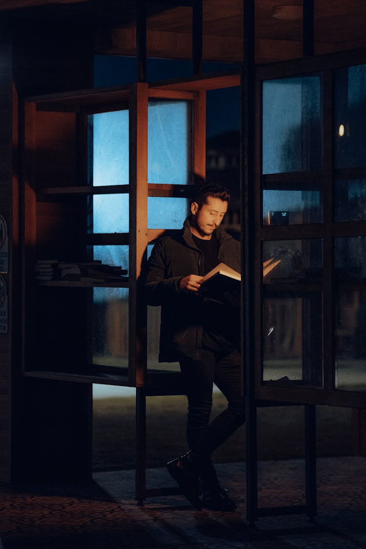 Man Standing And Reading Book