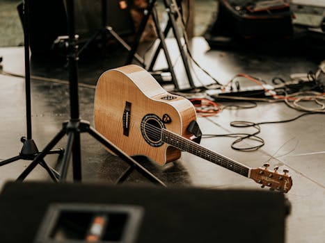 A close-up view of an acoustic guitar resting on a stage among musical equipment in Baku, Azerbaijan.