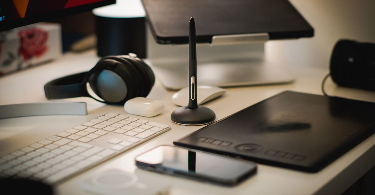 A sleek home office setup with digital tools including a tablet, keyboard, and headphones.