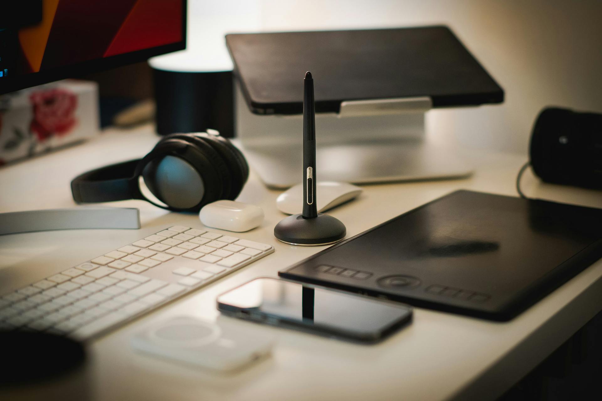 A sleek home office setup with digital tools including a tablet, keyboard, and headphones.