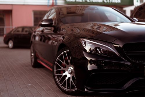 Free Close-up of a black car parked on urban pavement, showcasing modern design. Stock Photo