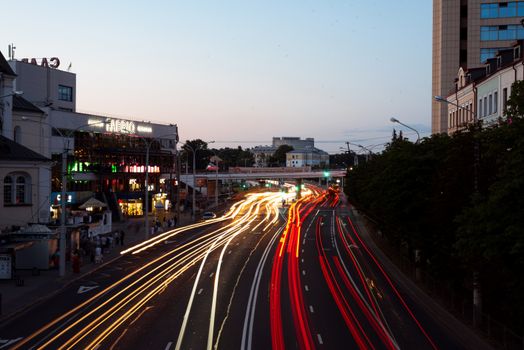 Vibrant city street scene with dynamic light trails depicting bustling traffic at dusk.