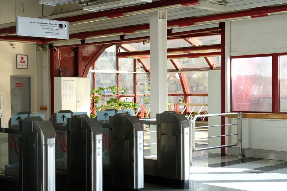Bright interior view of a metro station showing turnstiles and glass windows.