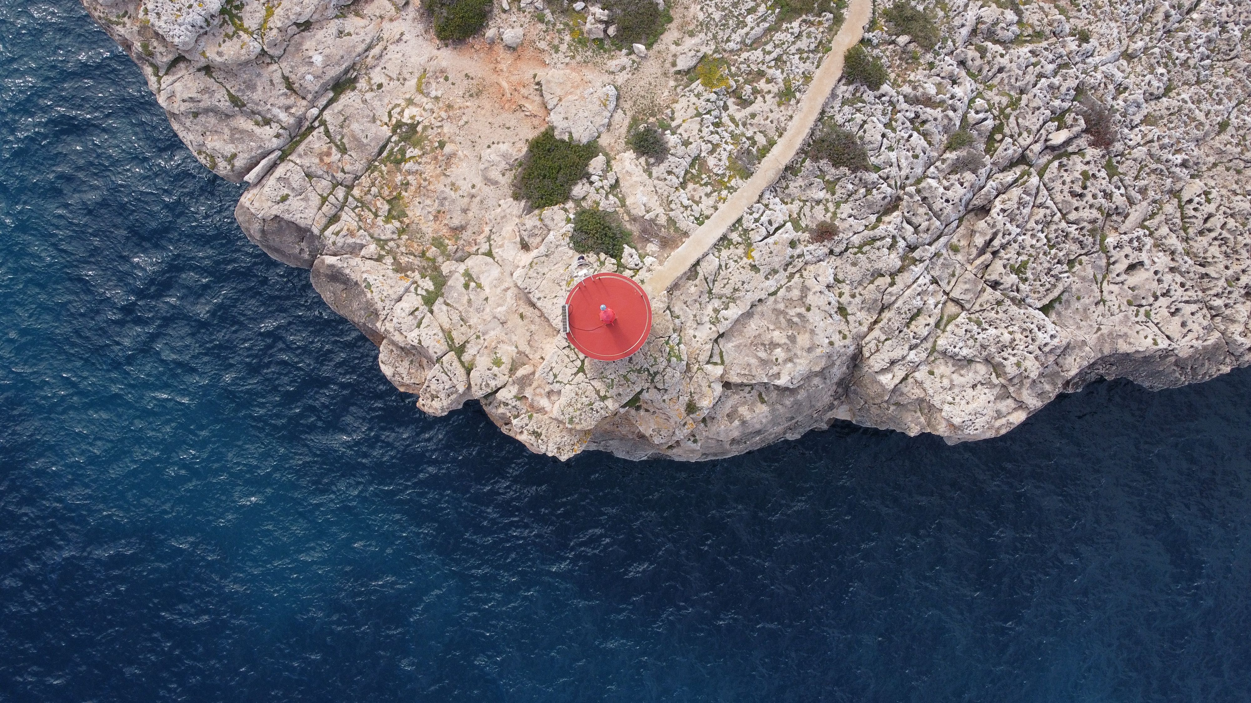 Birds Eye View of Sea Shore with Rocks and Lighthouse · Free Stock Photo