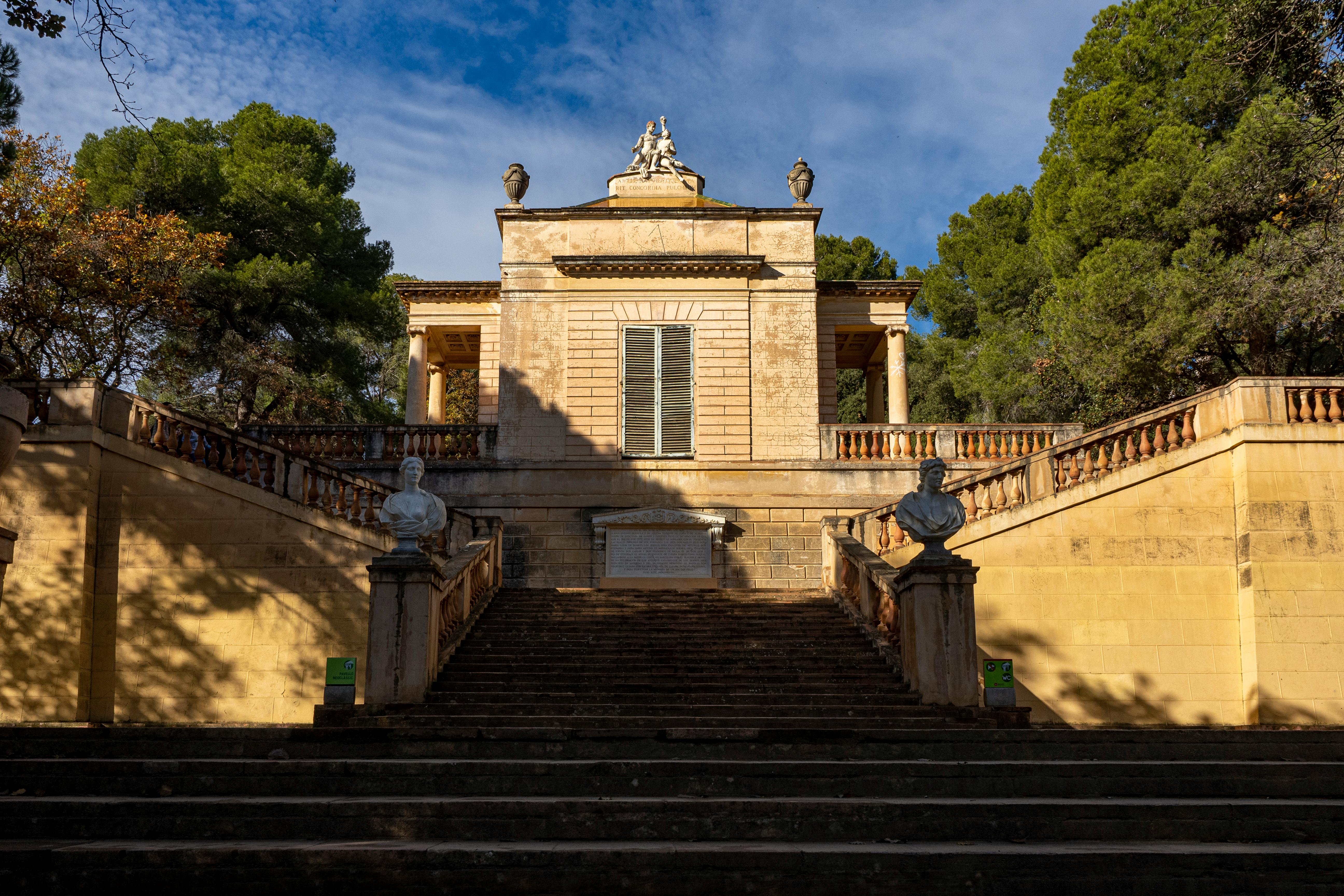 Beautiful neoclassical pavilion at Parc del Laberint d'Horta in Barcelona, Spain, bathed in sunlight.