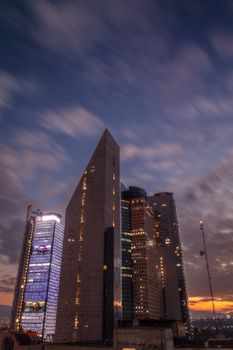 Vibrant Mexico City skyline with illuminated skyscrapers under a dramatic night sky.