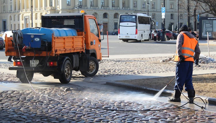 Man Cleaning Cobblestone Street