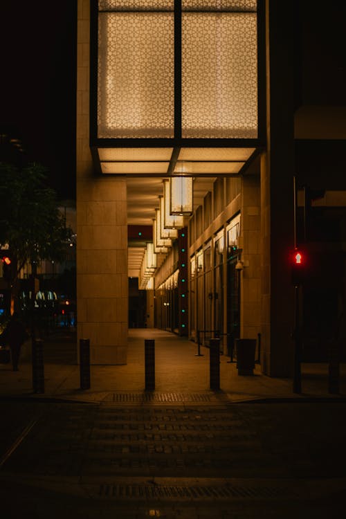 Pavement by Modern Building in City at Night