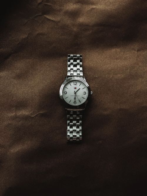 Free Stylish silver wristwatch with chain band displayed on a brown surface, perfect for fashion and accessory themes. Stock Photo