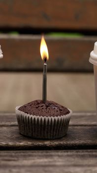 A chocolate muffin with a lit candle, perfect for celebrations or birthdays.