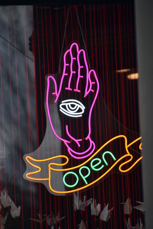 Free Vibrant neon sign depicting a hand with an eye symbol, featuring the word 'open'. Stock Photo