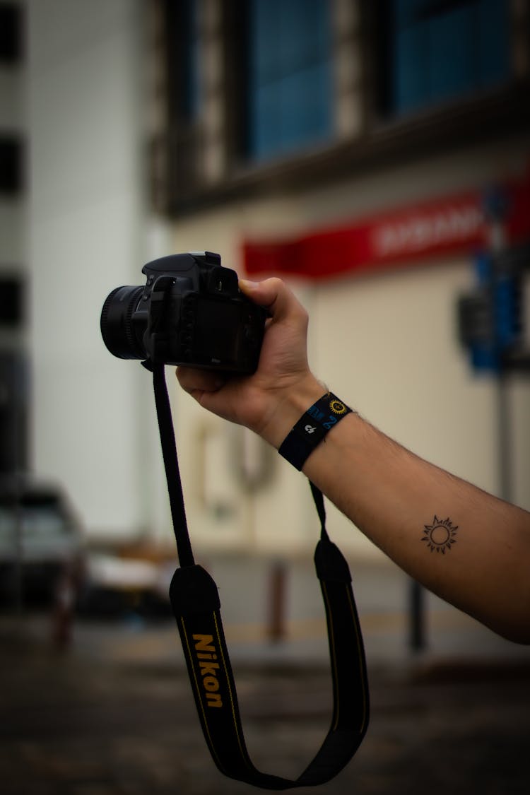 Tattoo On Arm Holding Camera