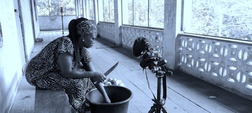 Gratis arkivbilde med afrikansk kvinne, bærbart videokamera, bord