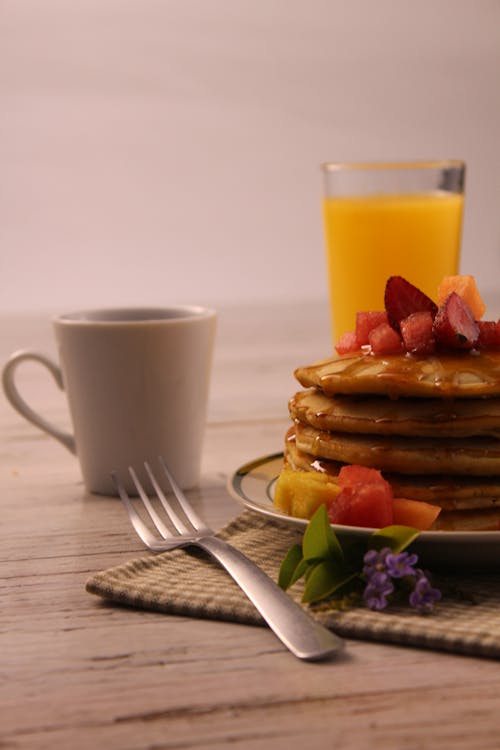 Free Pancakes with Fruit, a Cup of Coffee and a Glass of Orange Juice Stock Photo