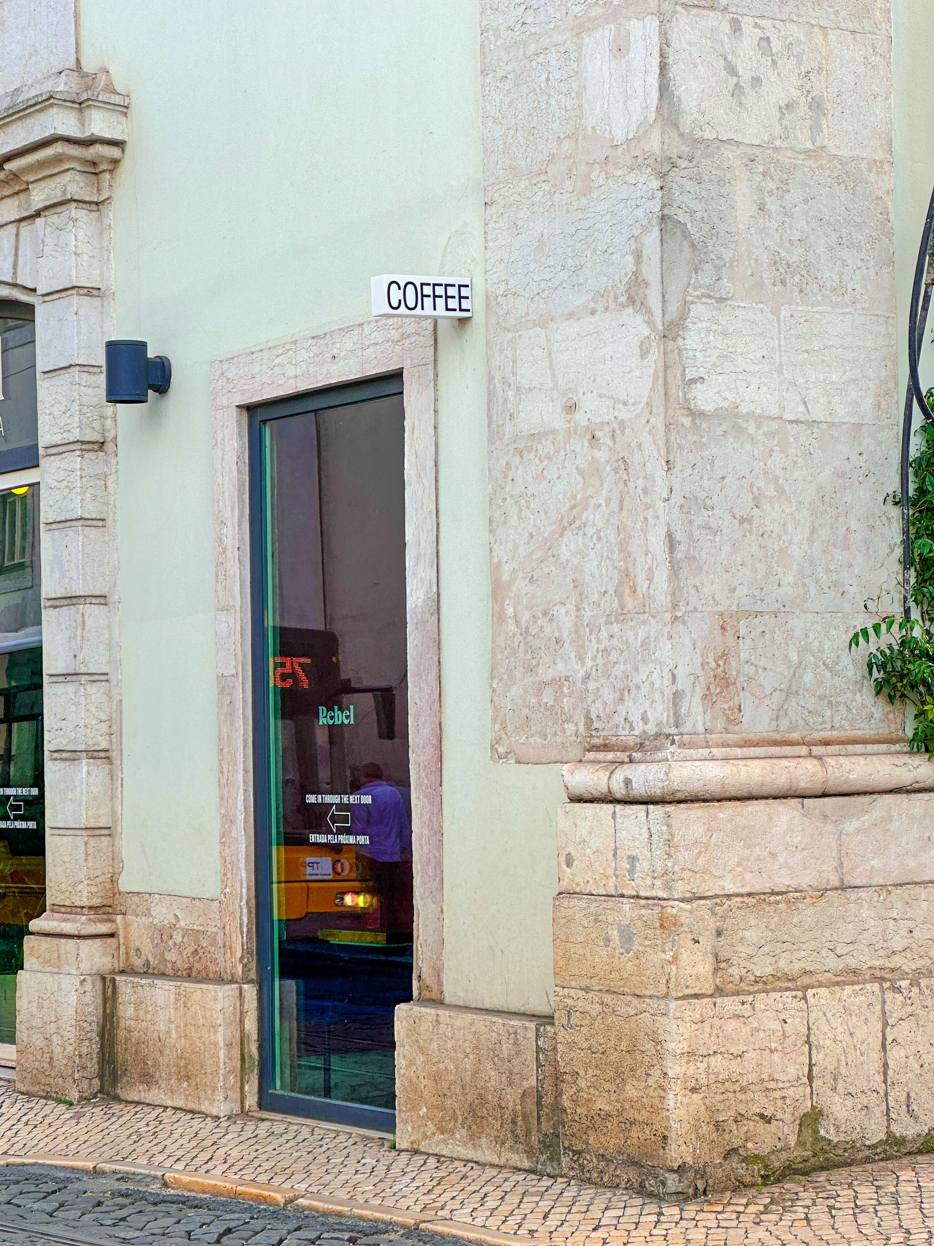 Free Detailed urban scene of a coffee shop entrance on a cobblestone street corner. Stock Photo