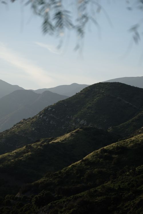 Free A serene view of lush green hills under a clear blue sky, perfect for nature lovers. Stock Photo