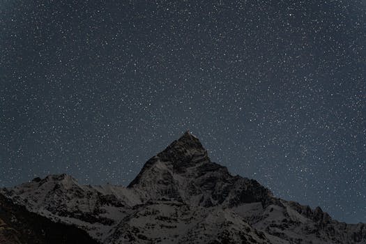 Long exposure of Machhapuchhare under a starry night sky in Pokhara, Nepal.