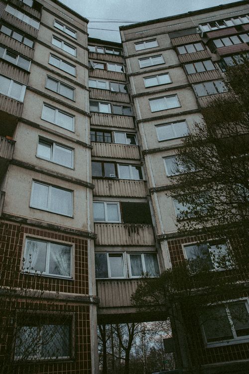 Free Tall residential building with modern and neglected facade under a gloomy sky. Stock Photo