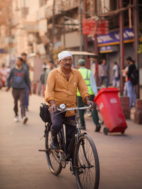 Mature Man Riding Bike on Busy Street