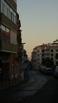 Quiet urban street view with buildings at dusk, capturing serene evening ambiance.