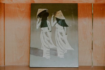 Painted panel of two robed figures under wide hats — Min An on Pexels