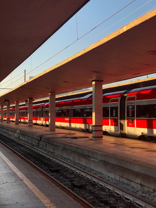 Free Sunlit red passenger train at Firenze railway station platform in Italy. Stock Photo