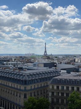 Beautiful panoramic view of Paris with the iconic Eiffel Tower under a majestic cloudy sky.