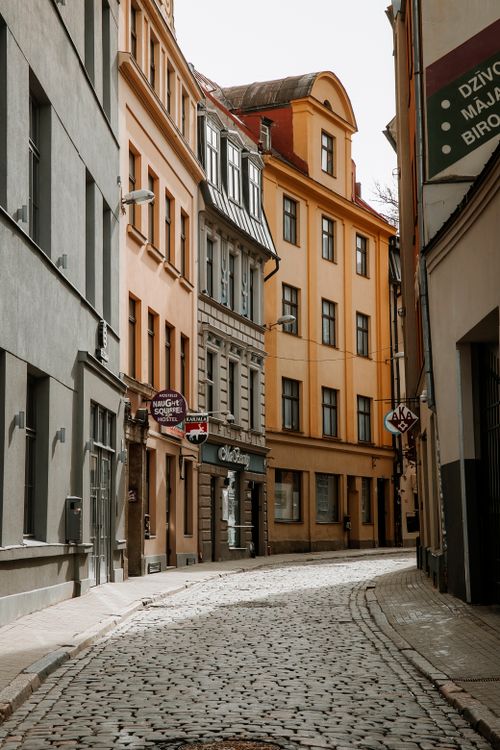 Free Explore the narrow cobblestone street lined with colorful historic buildings in a European old town. Stock Photo