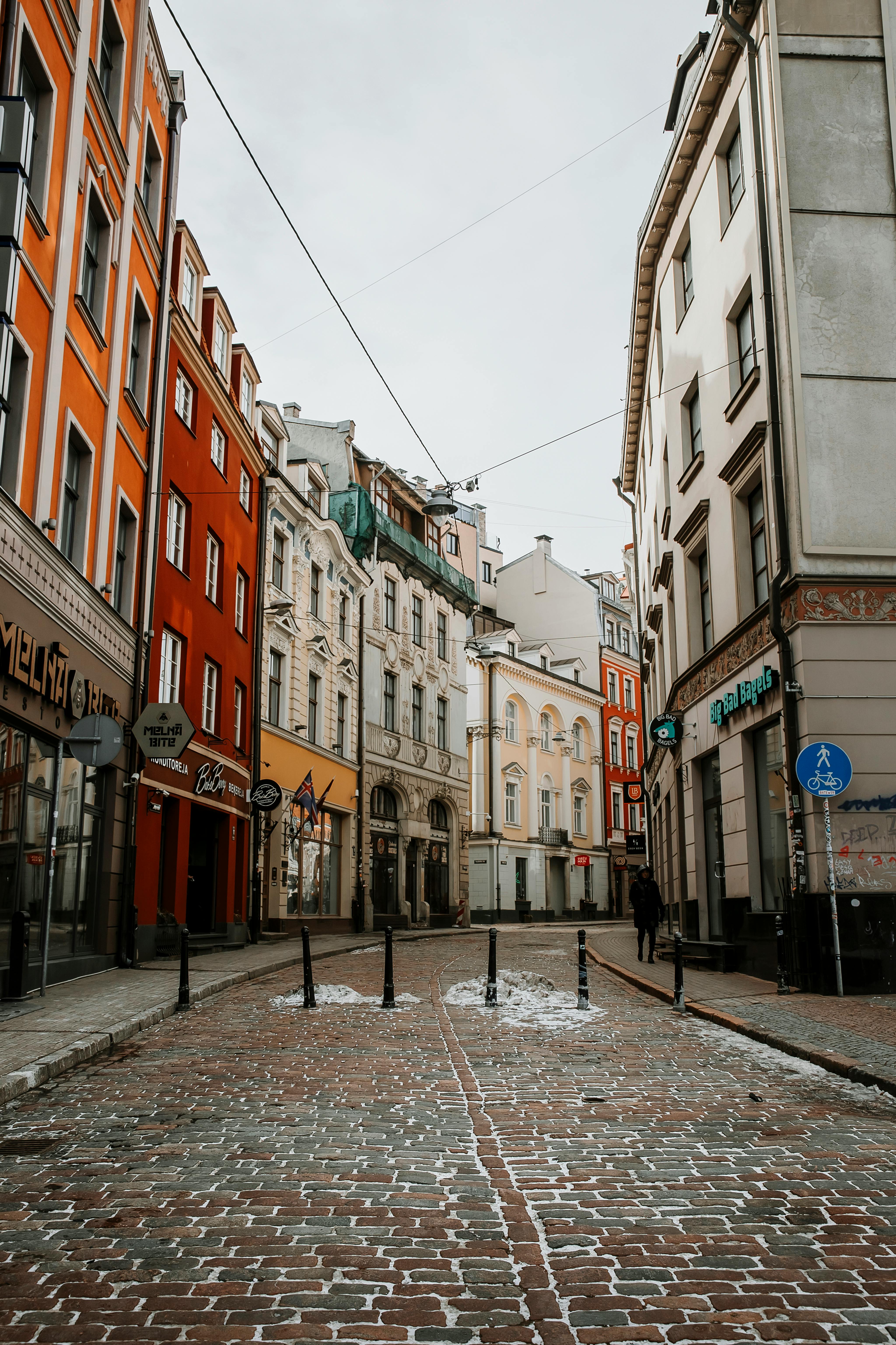 Cobblestone street in a historic European city with colorful facades and winter charm.