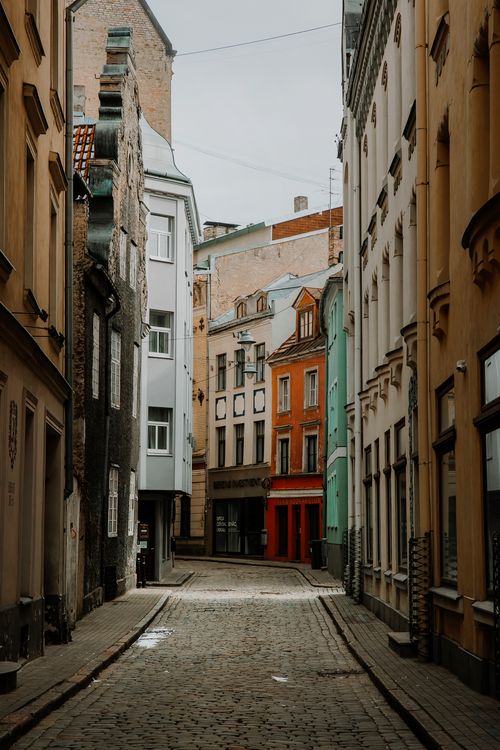 Free A picturesque cobblestone alley lined with colorful historical buildings, perfect for travel and architecture enthusiasts. Stock Photo