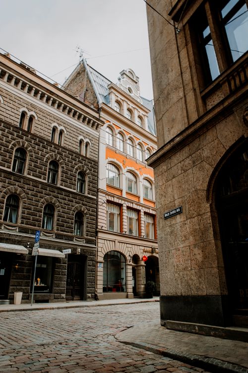 Free Explore a charming European city street with historic stone buildings, cobblestone roads, and classic architecture. Stock Photo