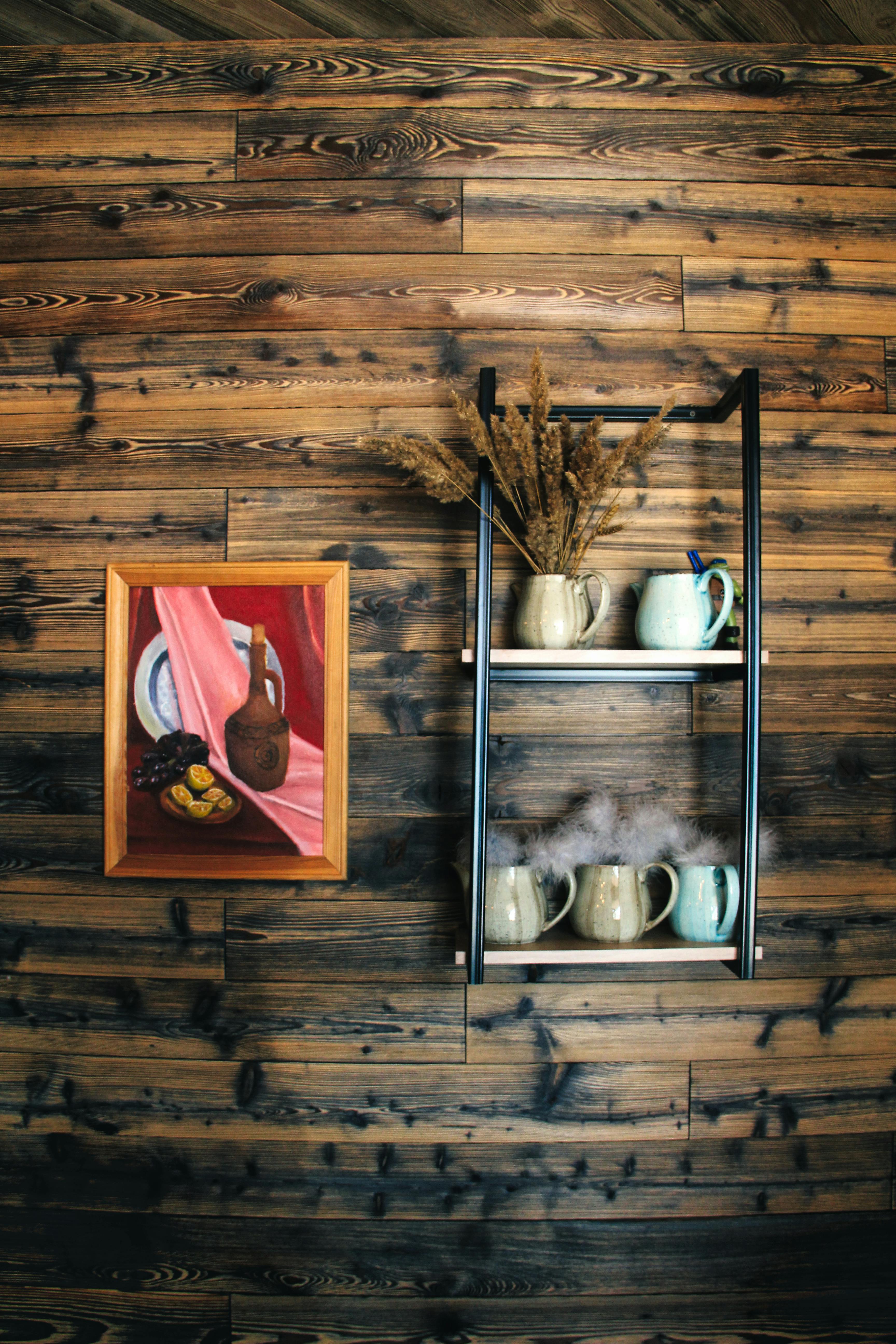 a wooden wall with a shelf and a coffee pot